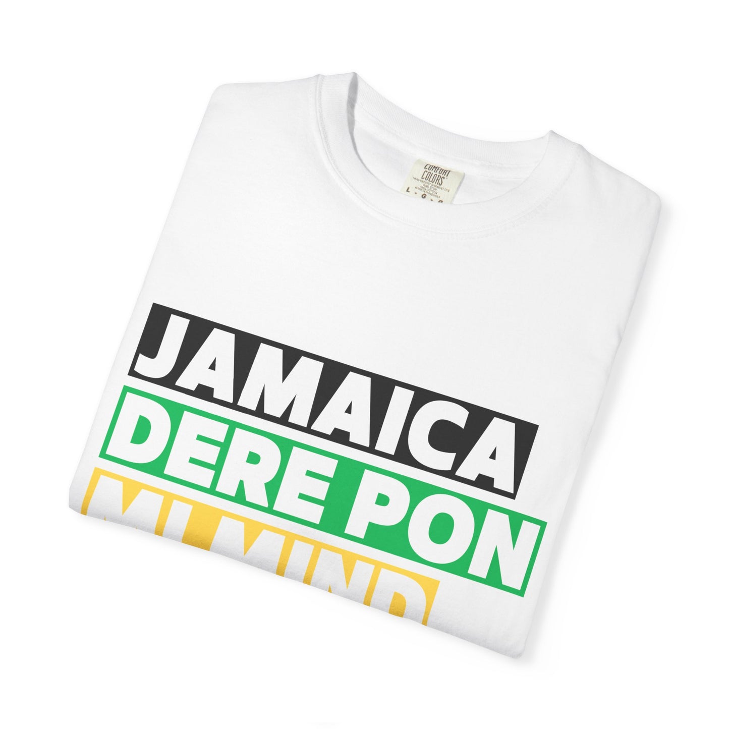 Folded white unisex graphic t-shirt with 'Jamaica dere pon mi mind' written in bold lettering on a black, green and gold background