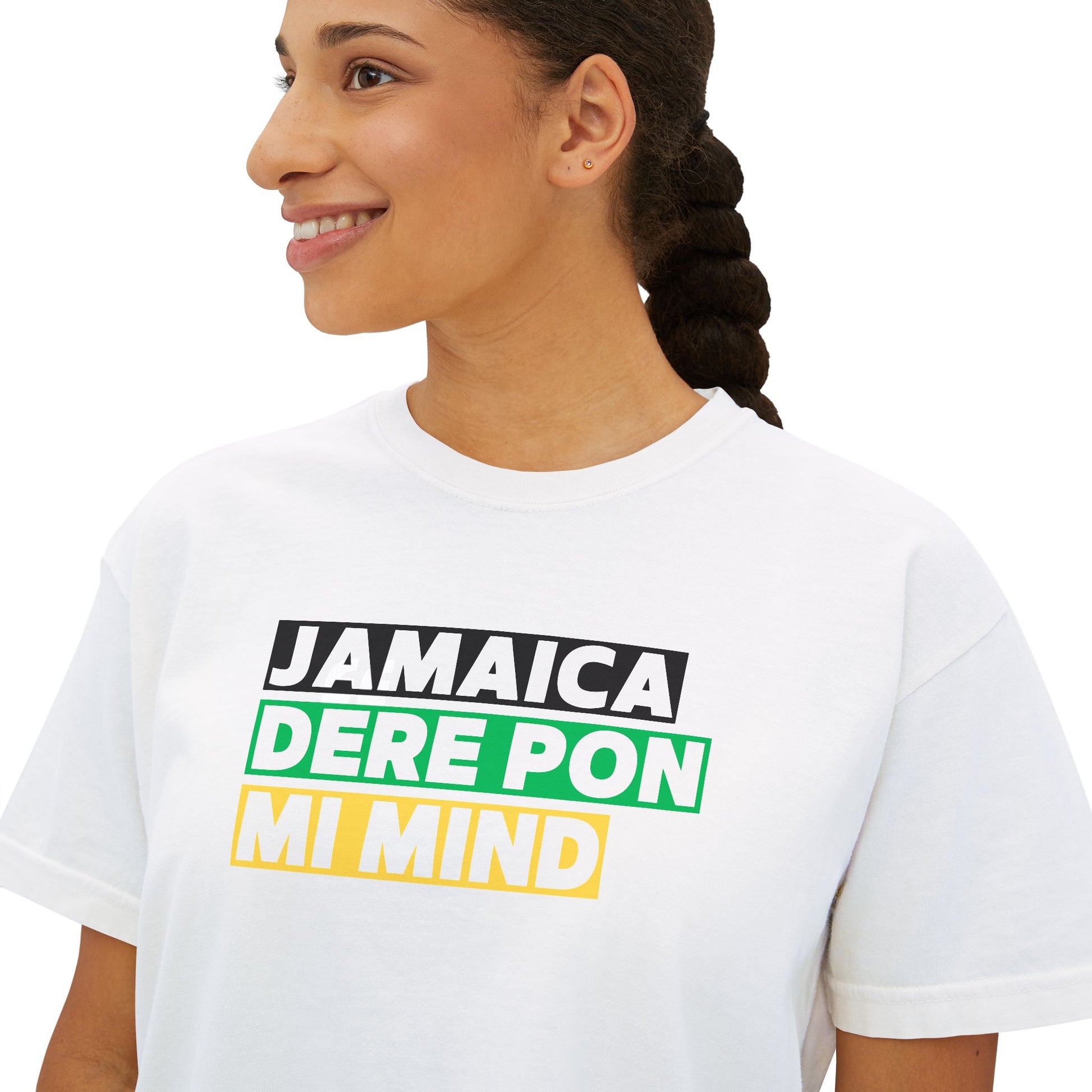 Close up of woman wearing white Cropped Graphic T-shirt with 'Jamaica Dere Pon Mi Mind' written in bold text with a black green and gold background.